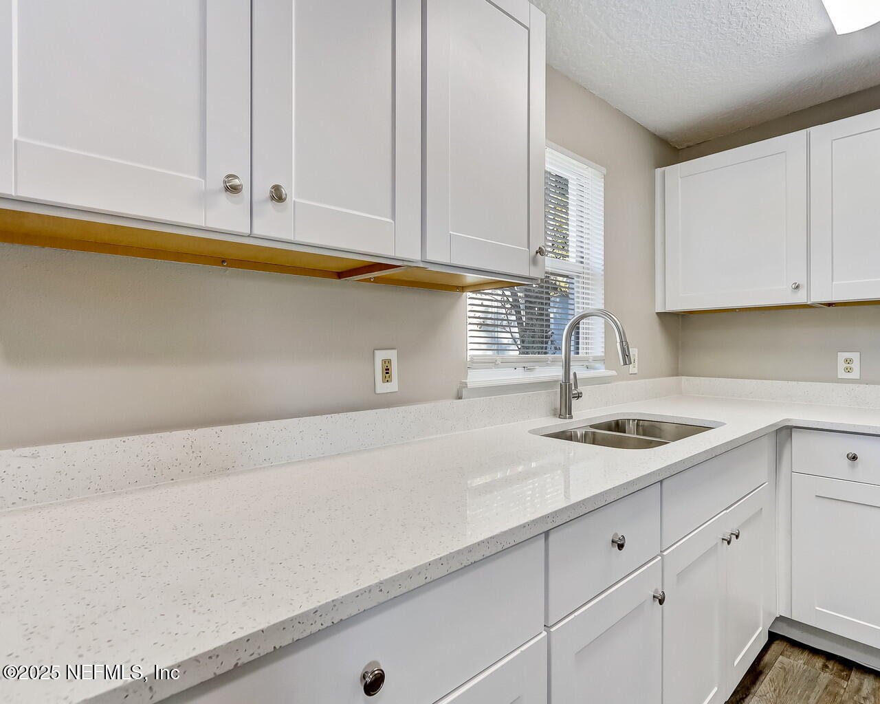 a kitchen with white cabinets and a sink