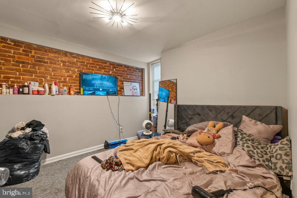 2436 East Preston Street Baltimore, MD 21213 - Photo 21 of 22 a bed sitting in a bedroom next to a window