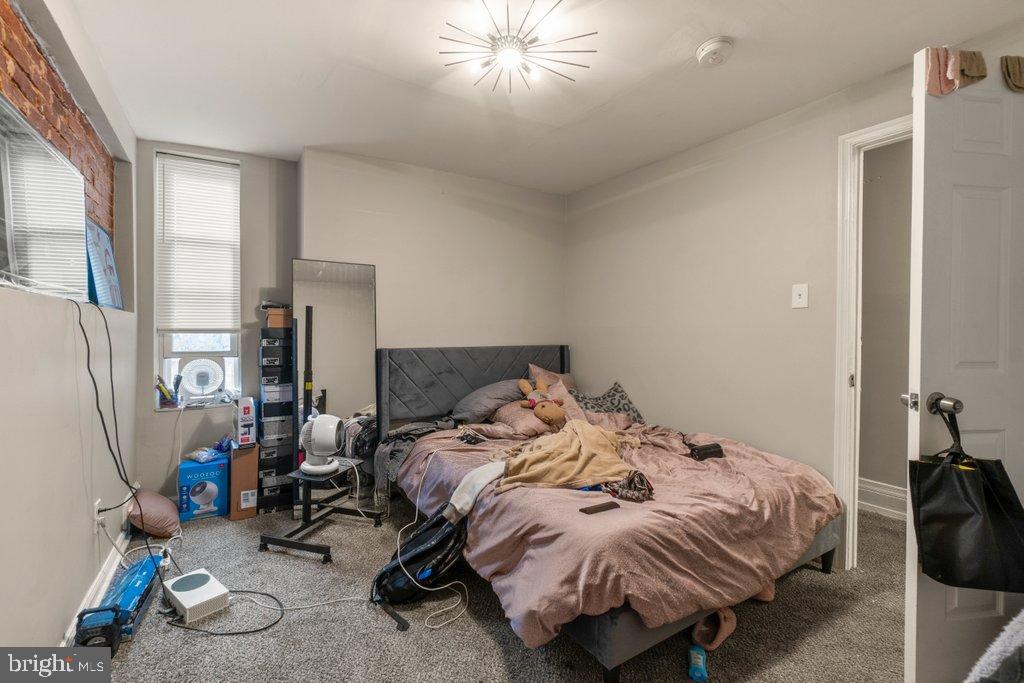 2436 East Preston Street Baltimore, MD 21213 - Photo 22 of 22 a bedroom with a bed a couch and a chandelier