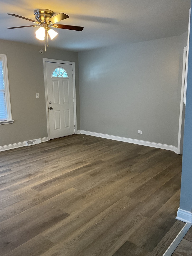 17031 Trapet Avenue Hazel Crest, IL 60429 - Photo 2 of 13 a view of an empty room with window and wooden floor