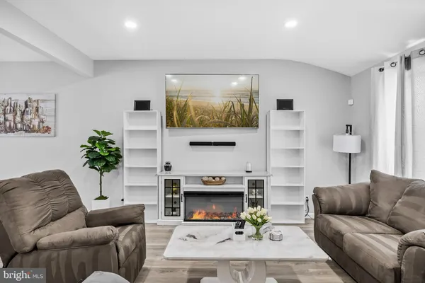a living room with furniture a fireplace and a flat screen tv