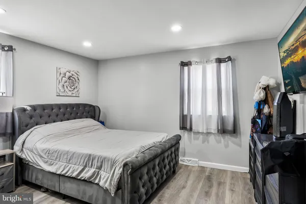 a bedroom with a bed and a flat tv screen on the dresser