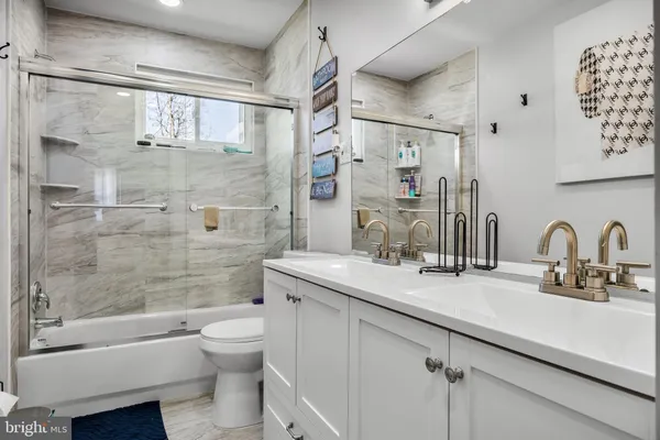 a bathroom with a granite countertop sink toilet tub and shower