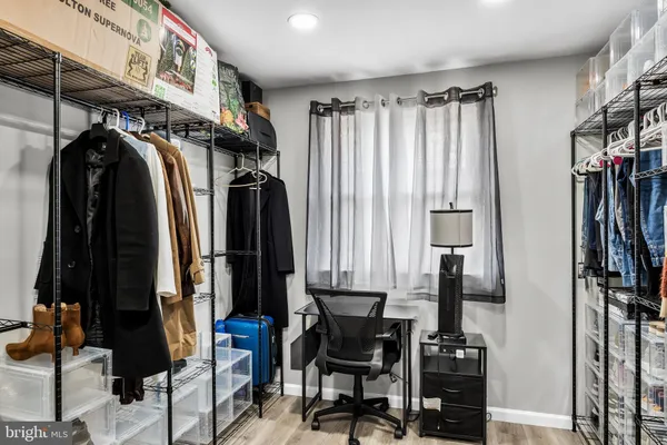 a view of walk in closet with clothes and shoes