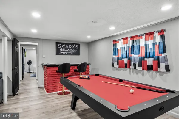 a room with furniture pool table and flat screen tv