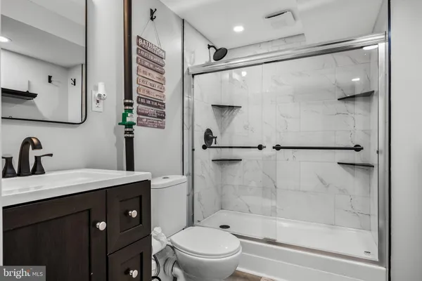 a bathroom with a bathtub shower sink vanity and toilet