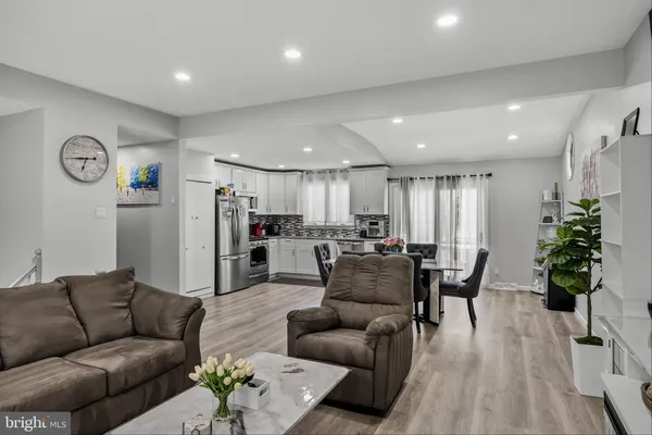 a living room with furniture kitchen view and a table