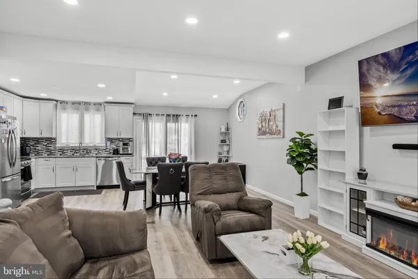 a living room with furniture white walls and kitchen view
