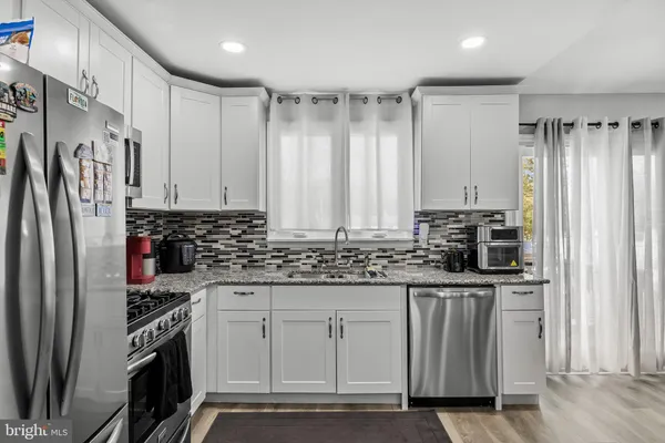 a kitchen with stainless steel appliances a stove sink and refrigerator