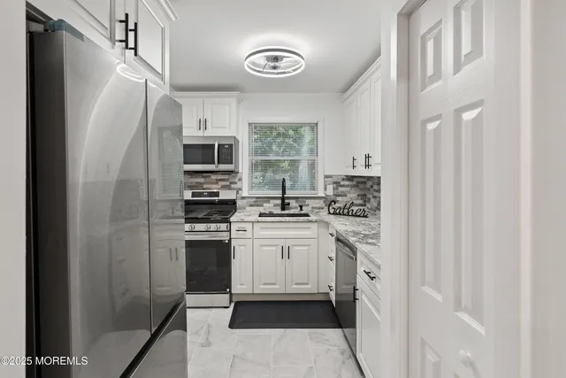 a kitchen with stainless steel appliances granite countertop a stove and a refrigerator