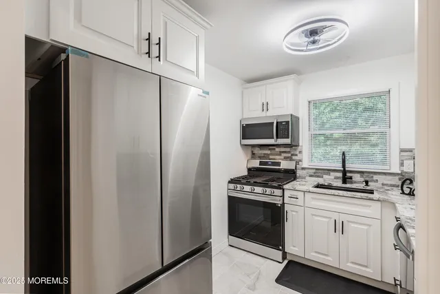 a kitchen with stainless steel appliances a refrigerator stove and microwave
