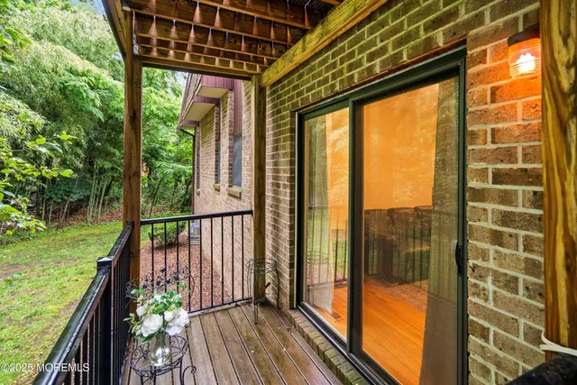 a view of a balcony with floor to ceiling windows with wooden floor