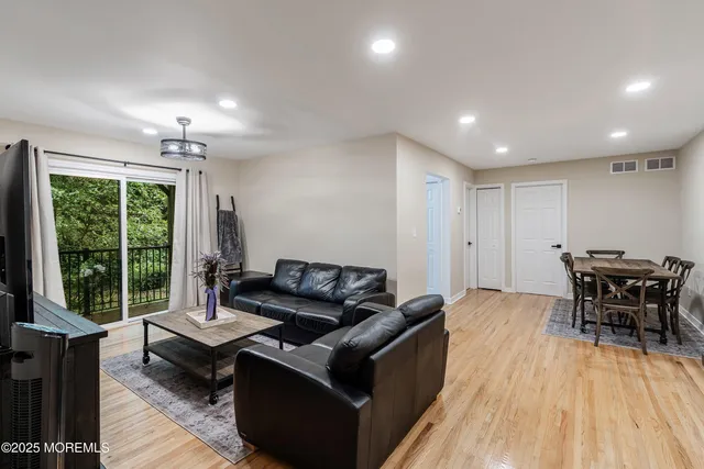a living room with furniture and a wooden floor