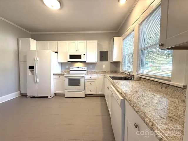 a kitchen with stainless steel appliances granite countertop a stove a sink and a refrigerator