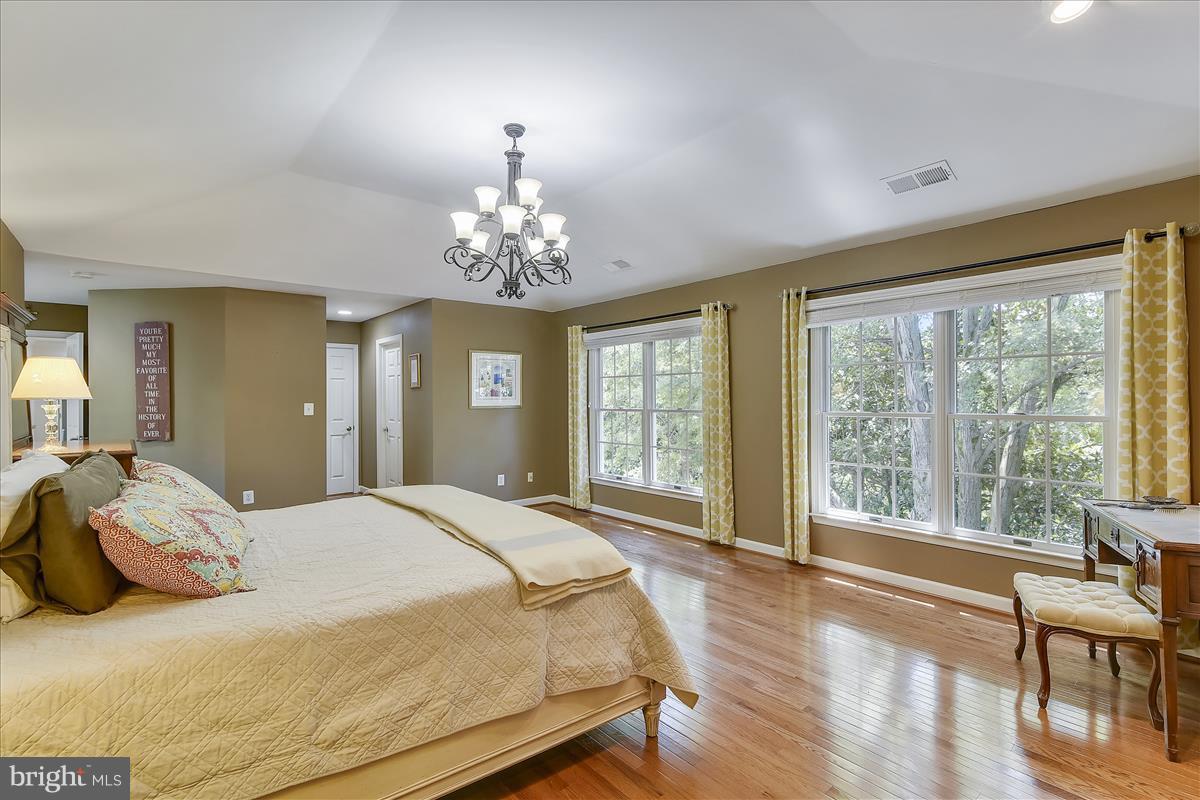 9409 Old Courthouse Road Vienna, VA 22182 - Photo 14 of 30 a spacious bedroom with a large bed and a chandelier