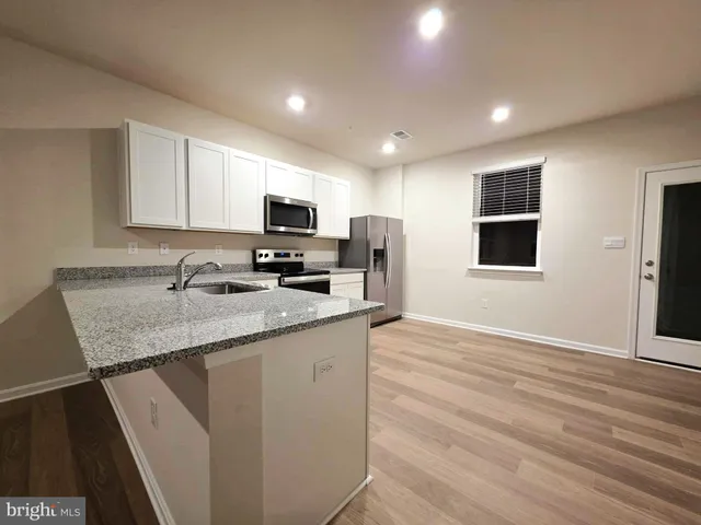 a kitchen with granite countertop a sink and a stove top oven