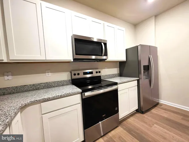 a kitchen with granite countertop a stove and a microwave