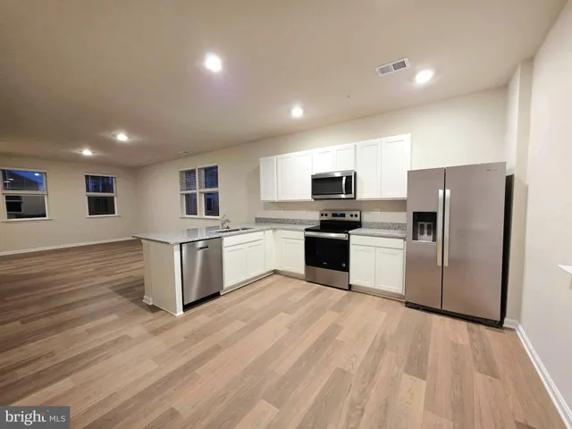 a large kitchen with cabinets and stainless steel appliances