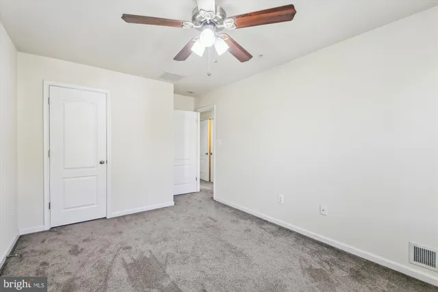an empty room with chandelier fan