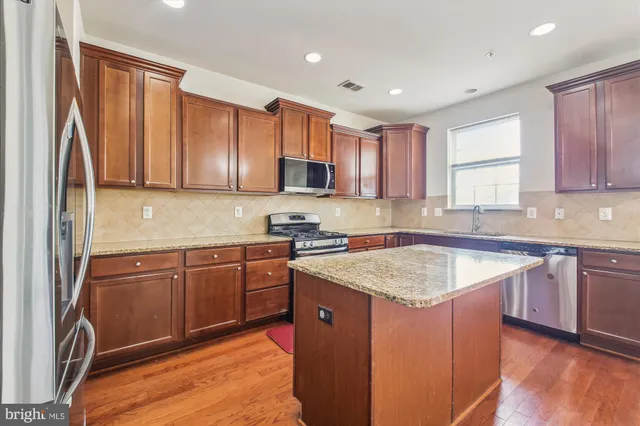 a kitchen with stainless steel appliances granite countertop a sink stove microwave and cabinets
