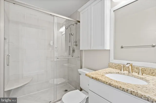 a bathroom with a granite countertop sink toilet and shower