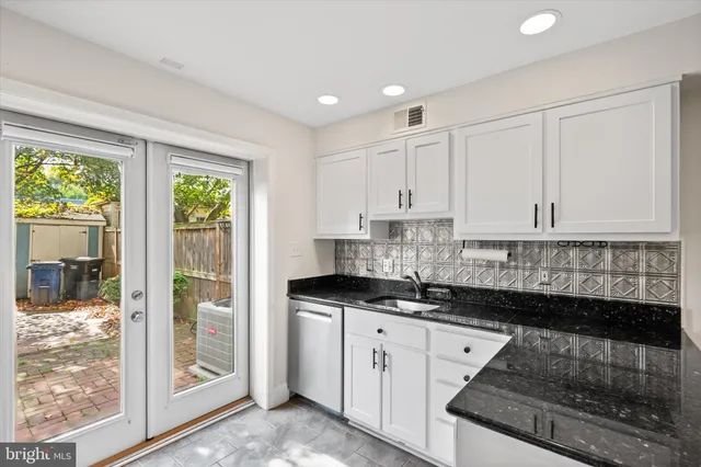 a kitchen with granite countertop a sink and cabinets