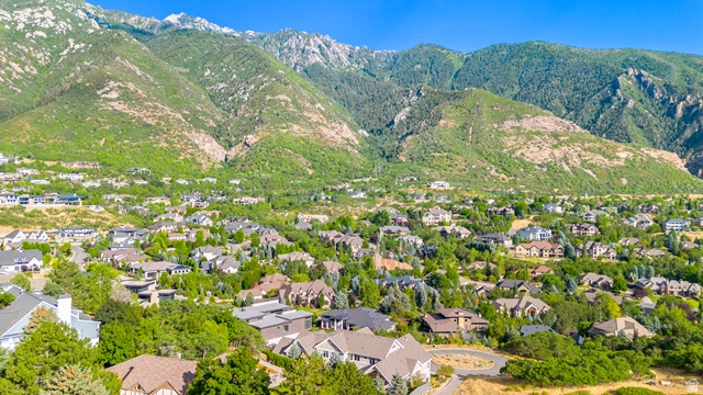3 Carriagewood Cove, Unit 1088 Sandy, UT 84092 - Photo 75 of 79 Residential neighborhood nestled at the base of verdant mountains, featuring various architectural styles, ample mature trees, and a clear blue sky