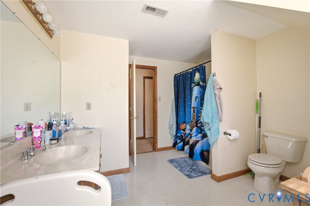 5612 Whitesell Road Louisa, VA 23093 - Photo 15 of 26 a bathroom with a tub sink mirror and toilet