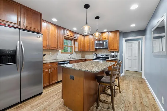 a kitchen with stainless steel appliances granite countertop wooden floors sink and cabinets