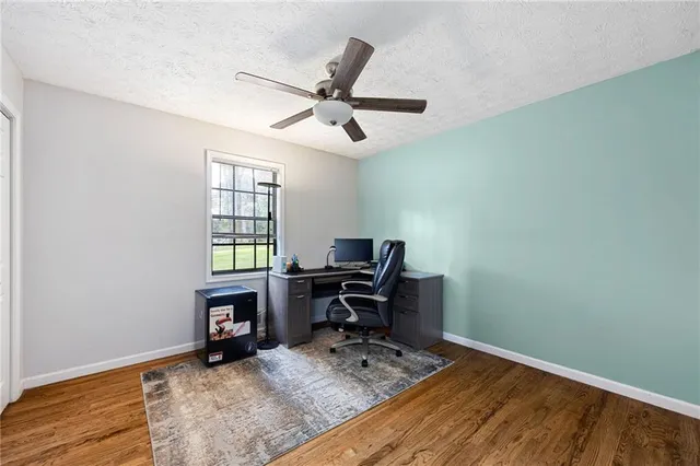 a view of a workspace with furniture and a window