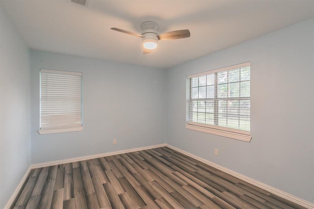 904 Sherman Street Tioga, TX 76271 - Photo 22 of 40 a view of an empty room with wooden floor and a window