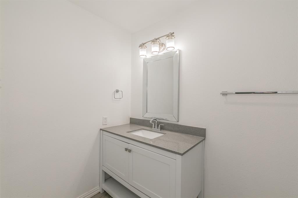 904 Sherman Street Tioga, TX 76271 - Photo 26 of 40 a bathroom with a sink and a mirror