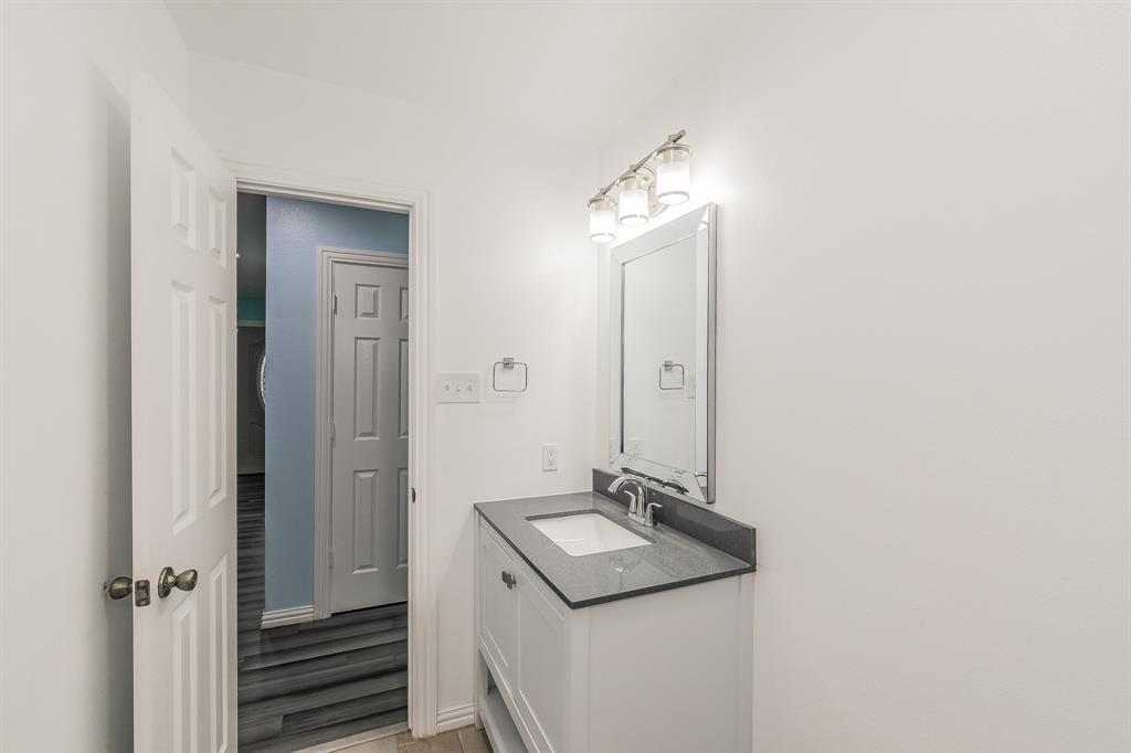 904 Sherman Street Tioga, TX 76271 - Photo 29 of 40 a bathroom with a sink and a mirror