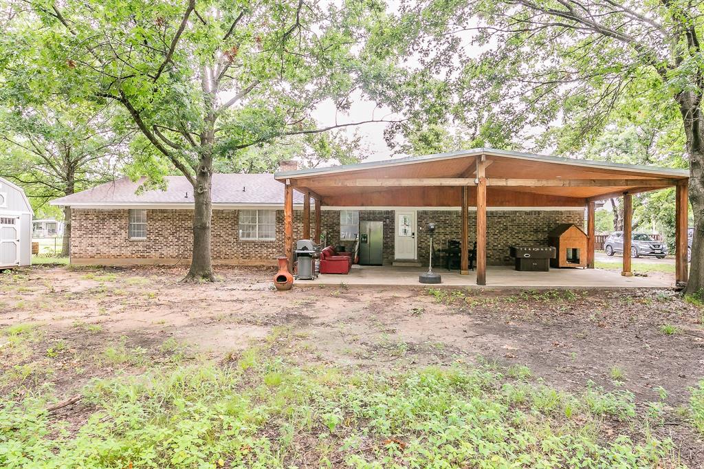 904 Sherman Street Tioga, TX 76271 - Photo 7 of 40 a view of a patio with a table and chairs under an umbrella