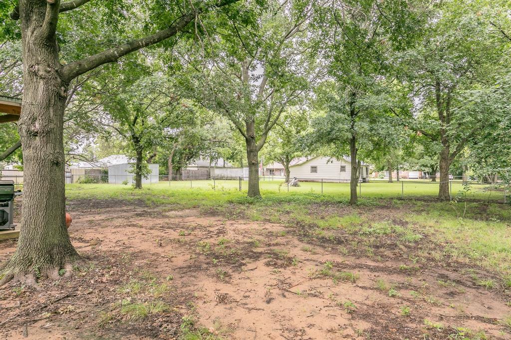 904 Sherman Street Tioga, TX 76271 - Photo 9 of 40 a view of a yard with tree s