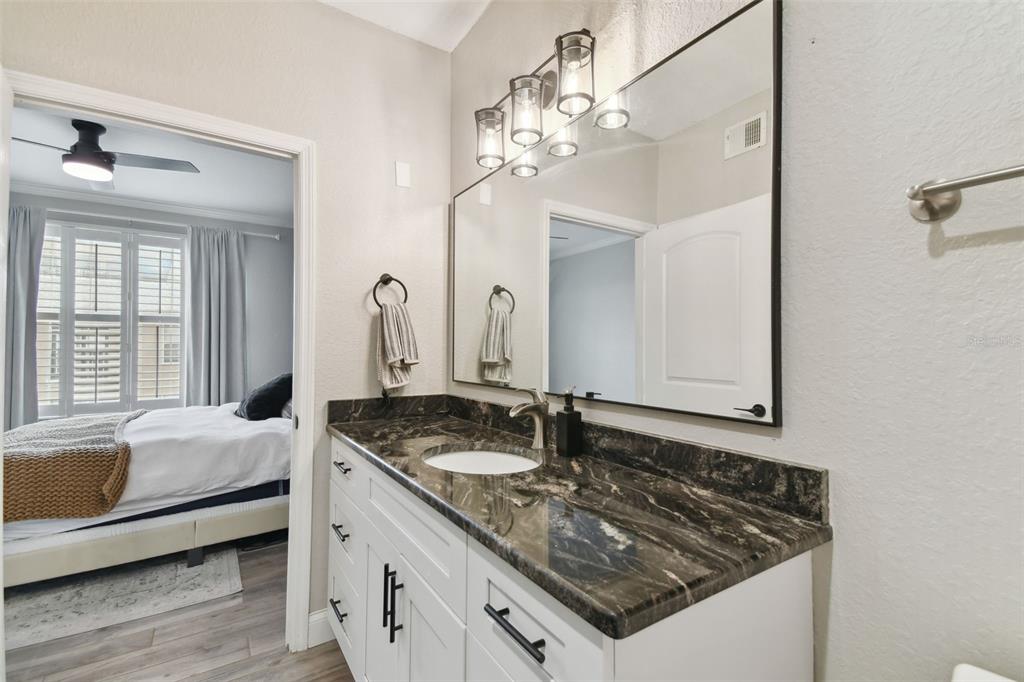 4221 West Spruce Street, Unit 1404 Tampa, FL 33607 - Photo 13 of 16 a bathroom with a granite countertop sink a large mirror and a window