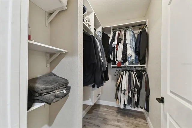 a view of walk in closet with clothes and shoes