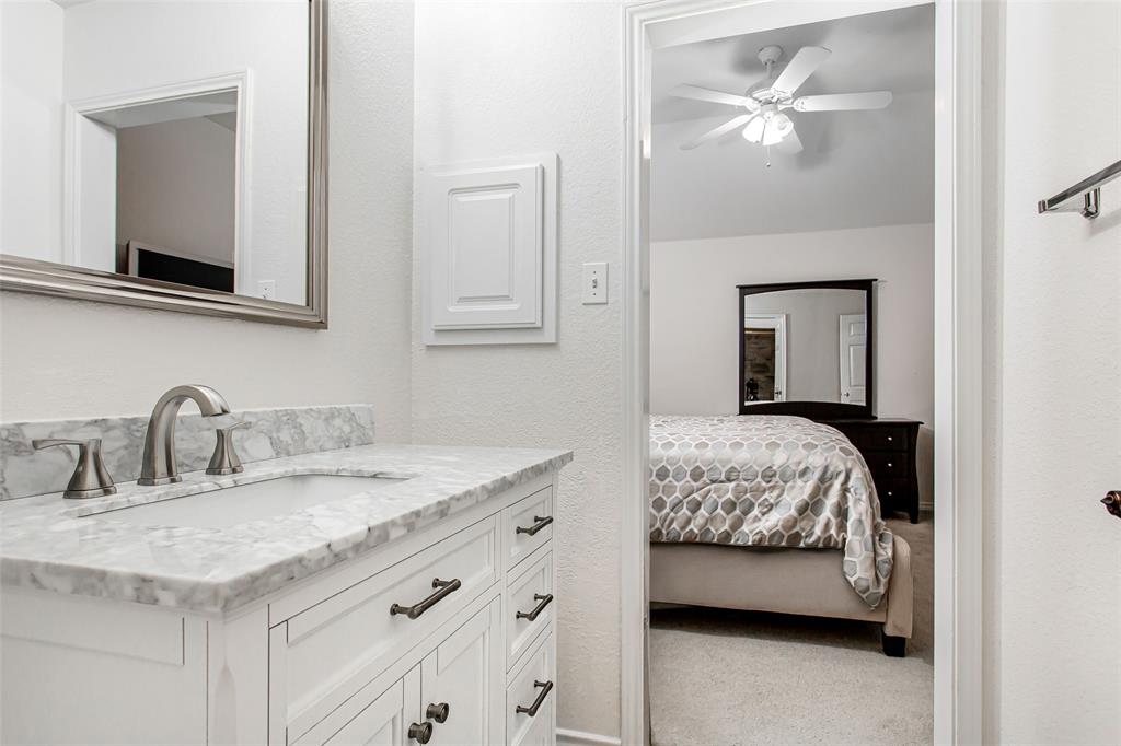5916 Mossbrook Trail Dallas, TX 75252 - Photo 32 of 40 a en suite bathroom with a granite countertop sink and a mirror
