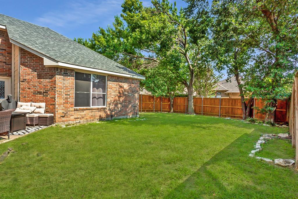 5916 Mossbrook Trail Dallas, TX 75252 - Photo 38 of 40 a view of a backyard with table and chairs and a large tree
