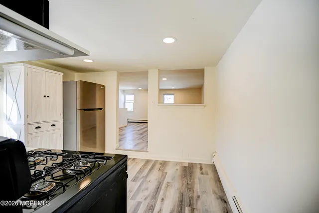 a kitchen with granite countertop white cabinets and stainless steel appliances
