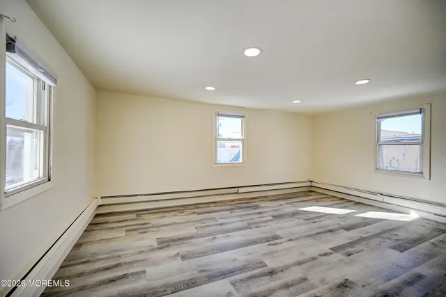 a view of empty room with wooden floor
