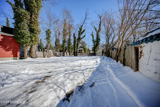 a view of a white house with a yard covered in snow