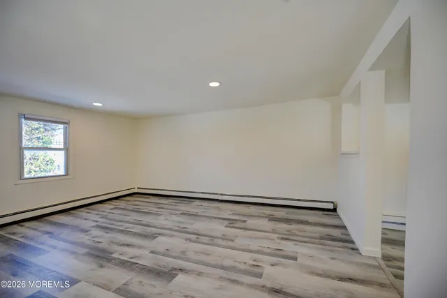 a view of wooden floor in an empty room with a window