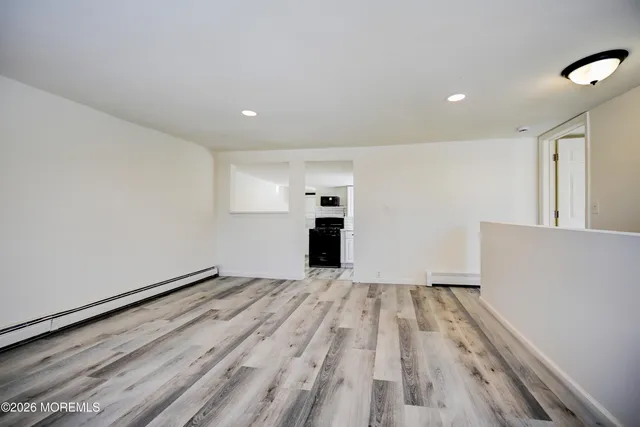 a view of empty room with wooden floor