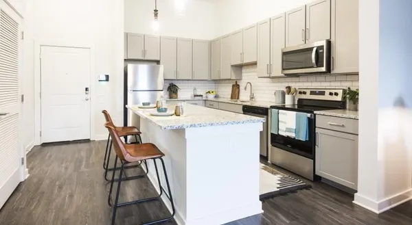 a kitchen with stainless steel appliances a stove a sink refrigerator and a microwave
