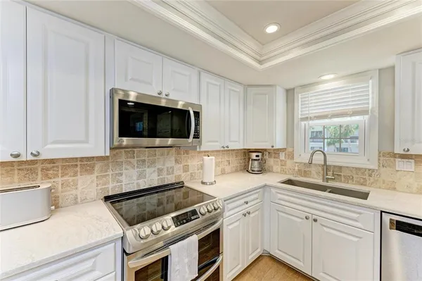 a kitchen with stainless steel appliances a sink a stove a microwave and cabinets