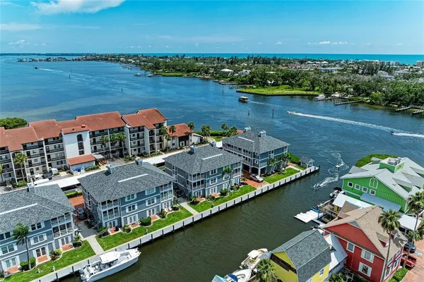an aerial view of residential houses with outdoor space and lake view