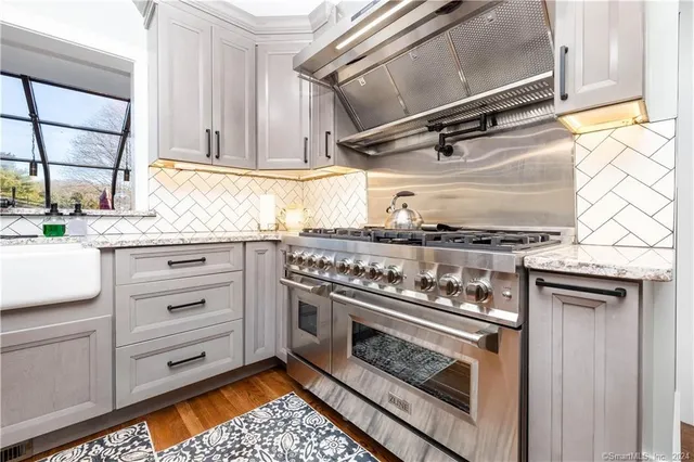 a kitchen with a stove and white cabinets