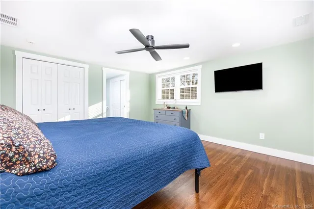 a spacious bedroom with a bed and a flat screen tv