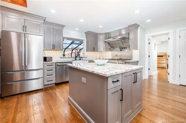 a kitchen with a refrigerator sink and cabinets